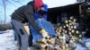 Adománytűzifát pakolnak le egy háznál a Cserkeszőlő-környéki tanyavilágban 2019. január 9-én