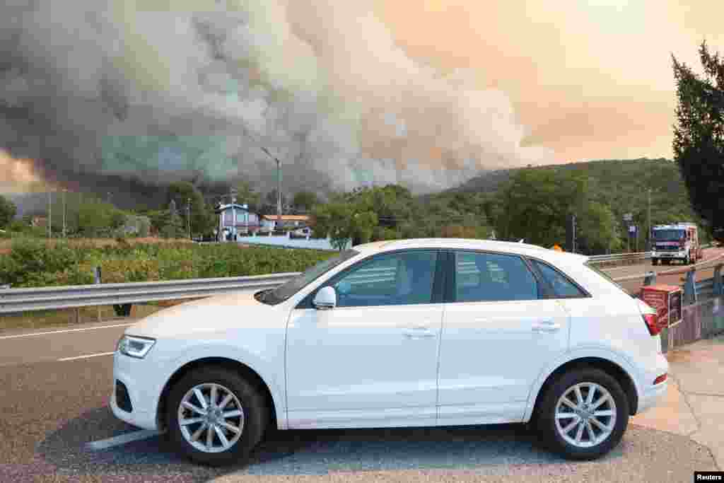 Ljudi pored atumobila u blizini granice sa Italijom, Miren Slovenija, 20. juli 2022. Izgledalo je da se požar smirio, ali je kasnije ponovo eskalirao.