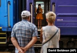 O fetiță ucraineană își ia rămas bun de la bunicii ei într-o gară din Pokrovsk, regiunea Donețk, estul Ucrainei, 2 august 2022.