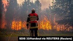 Vatrogasac radi na suzbijanju požara koji je izbio u blizini Landirasa, dok se šumski požari nastavljaju širiti u regiji Gironde u jugozapadnoj Francuskoj, juli 2022.