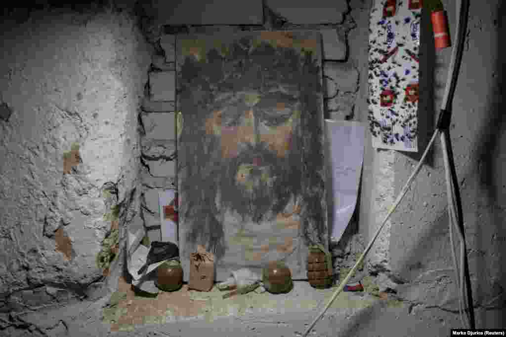 Ručne granate pored ikone Hrista u operativnoj bazi bataljona. &quot;Sada je to više artiljerijski rat. To je teži rat, strašniji rat, u kojem se mogu boriti samo ljudi koji su jaki duhom&quot;, rekao je Dzvin, terenski komandant bataljona koji je tražio da ga identifikuju samo po pseudonimu, iz sigurnosnih razloga.