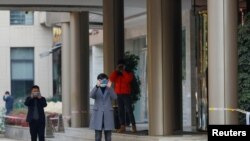 Kinseki službenici fotografišu fotografa ispred hotela u Vuhanu gdje su smješteni članovi tima Svjetske zdravstvene organizacije, 15. januar, 2021. 