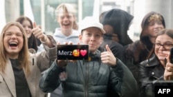 Tineri suporteri ai liderului creștin-democrat, Friedrich Merz, în apropierea complexului de clădiri ale parlamentului de la Berlin, după anunțarea acordului de coaliție, pe 9 aprilie 2025