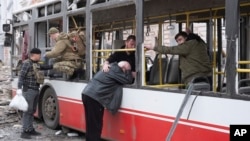 Un bărbat, plângând sprijinit de geamul unui autobuz deteriorat, în urma loviturilor rusești cu rachetă de la Sumî, pe 13 aprilie 2025
