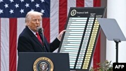 Президентът на САЩ Доналд Тръмп показва таблица с новите високи мита, които въвежда, 2 април 2025 г.