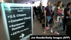 Pasagerii așteaptă la coada pentru ghișeele de control automatizat al pașapoartelor pe Aeroportul Internațional Miami, 4 martie 2015.