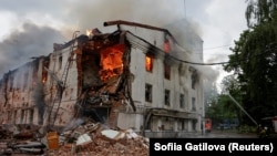 Pompierii sting incendiul dintr-un bloc lovit în timpul atacul rusesc cu drone asupra orașului ucrainean Harkov, pe 7 iunie.