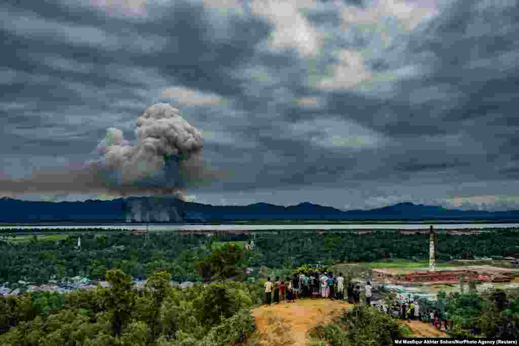 Група біженців Рохінджа у Кокс-Базарі, Бангладеш, спостерігає, як палають будинки через кордон у сусідній М&rsquo;янмі