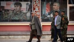 FILE: Afghan Vice President Abdul Rashid Dostum (L) walks at his headquarters in Sheberghan, capital of northern Jowzjan province on July 28.