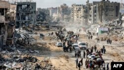 În imagine, palestinieni care merg printre dărâmături, în orașul Jabalia, luni, 20 ianuarie 2025, la o zi după ce acordul de încetare a focului în Fâșia Gaza a început.