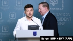 Former Ukrainian President Leonid Kuchma walks behind current incumbent Volodymyr Zelenskiy during a briefing in Kyiv earlier this year. 