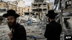 Ultraortodox zsidó férfiak az iráni rakétatámadás után Bnéj Brakban, Tel-Avivtól keletre, 2025. június 16-án