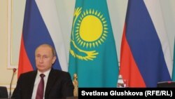 Президент России Вдалимир Путин на фоне государственных флагов Казахстана и России. Архивное фото.