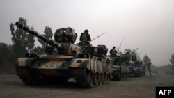 FILE: Pakistani army tanks form a column during a ground military operation in Miran Shah, the main town in North Waziristan.