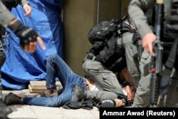 Poliția israeliană reține un palestinian în timpul ciocnirilor de la complexul care găzduiește Moscheea Al-Aqsa, cunoscută musulmanilor drept Sanctuarul Nobil și evreilor ca Muntele Templului, în orașul vechi din Ierusalim, 10 mai 2021.