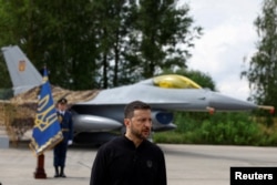 Президент Владимир Зеленский выступает в День Воздушных сил на фоне истребителя F-16. Август 2024 года