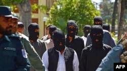 Afghan security forces escort alleged Islamic State fighters being presented to the media at the police headquarters in Jalalabad on May 29. They included one Iranian citizen.