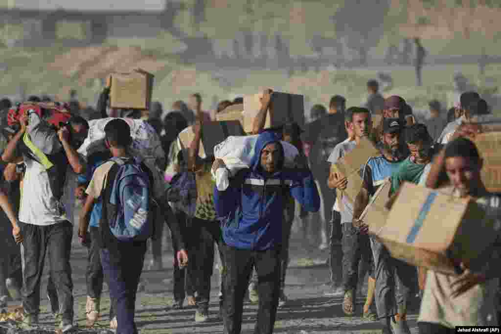 Palestinezët duke bartur ndihmat që ua sollën kamionët.