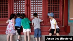 Stopa nataliteta u Kini opada godinama. (Foto: Djeca gledaju kroz prozor u Zabranjeni grad u centru Pekinga, Kina, 31. jul 2018.)