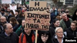 „Grecia își omoară copiii”, susține pe o pancartă o fată care participă la protestul de vineri, în fața Parlamentului elen. 