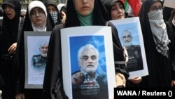 O demonstrație anti-israeliană la Teheran, pe 13 iunie 2025, după atacurile israeliene. Oamenii poartă portrete ale generalilor și oamenilor de știință din domeniul nuclear uciși în atac.