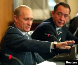 Președintele Vladimir Putin alături de ministrul mediilor de informare Mihail Lesin la o întîlnire cu presa locală la Vladivostok, în august 2002