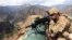 FILE: A U.S. soldier looks through his sniper scope in the province of Kunar in eastern Afghanistan.
