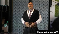 Oleksandr Usyk, i veshur si një kozak ukrainas, shfaq brezat e tij prej kampioni para konferencës së përbashkët për shtyp me britanikun Anthony Joshua në Xheda, Arabinë Saudite, gusht 2022.