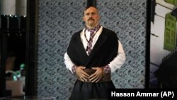 Александр Усик в образе украинского козака демонстрирует свои будущие чемпионские пояса перед совместной пресс-конференцией с британцем Энтони Джошуа в Джидде, Саудовская Аравия, август 2022 год