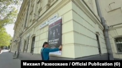 Сотрудник театра в Севастополе снимает афишу спектакля "Ветер шумит в тополях" режиссера Римаса Туминаса после отмены гастролей московского театра им. Вахтангова местными властями