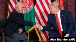 Then U.S. President Donald Trump (right) shakes hands during a meeting in 2019 with Afghan President Ashraf Ghani, who has now left the country in the face of the Taliban's rapid advance.