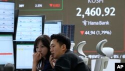 Comercianții de valută la bursa Kospi din Seul joi.