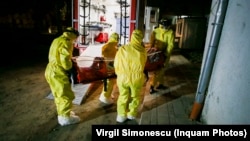 Ambulanțieri care transportă cu izoleta un pacient depistat cu coronavirus