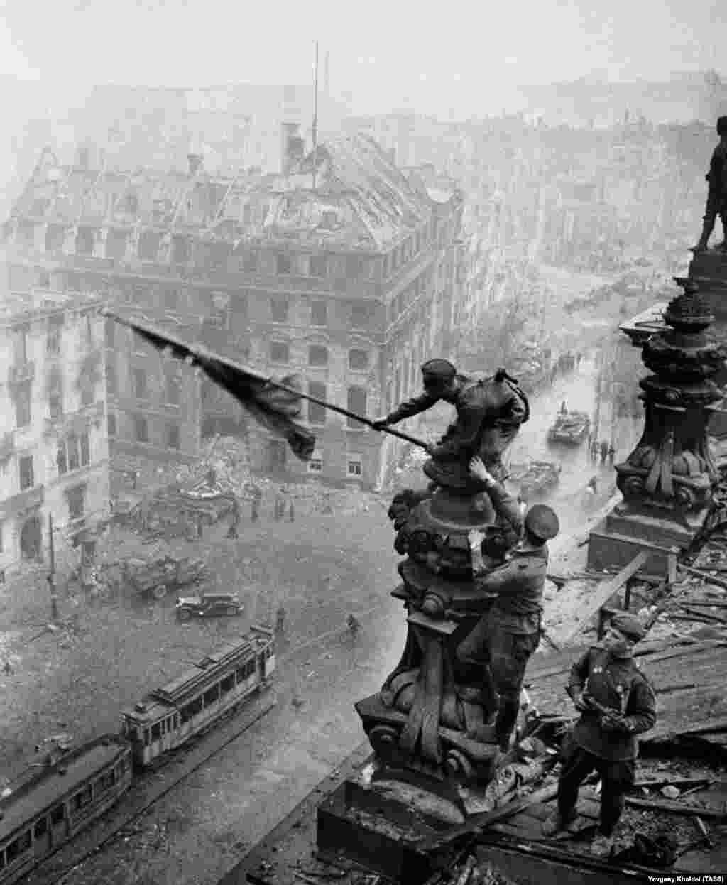 Un alt instantaneu al aceleiași scene arată un soldat cu un ceas la ambele mâini - o dovadă a jafurilor comise de Armata Roșie. Khaldei a spus că șeful lui de la agenția sovietică de știri TASS l-a chemat la el în birou să-i arate detaliul incriminant, spunîndu-i : &bdquo;Un adevărat soldat al Armatei Roșii nu jefuiește... aranjeaz-o repede, dă asta jos de pe negativ&rdquo;. Fotograful de 28 de ani a folosit o pioneză ca să zgîrie al doilea ceas de mână de pe film.