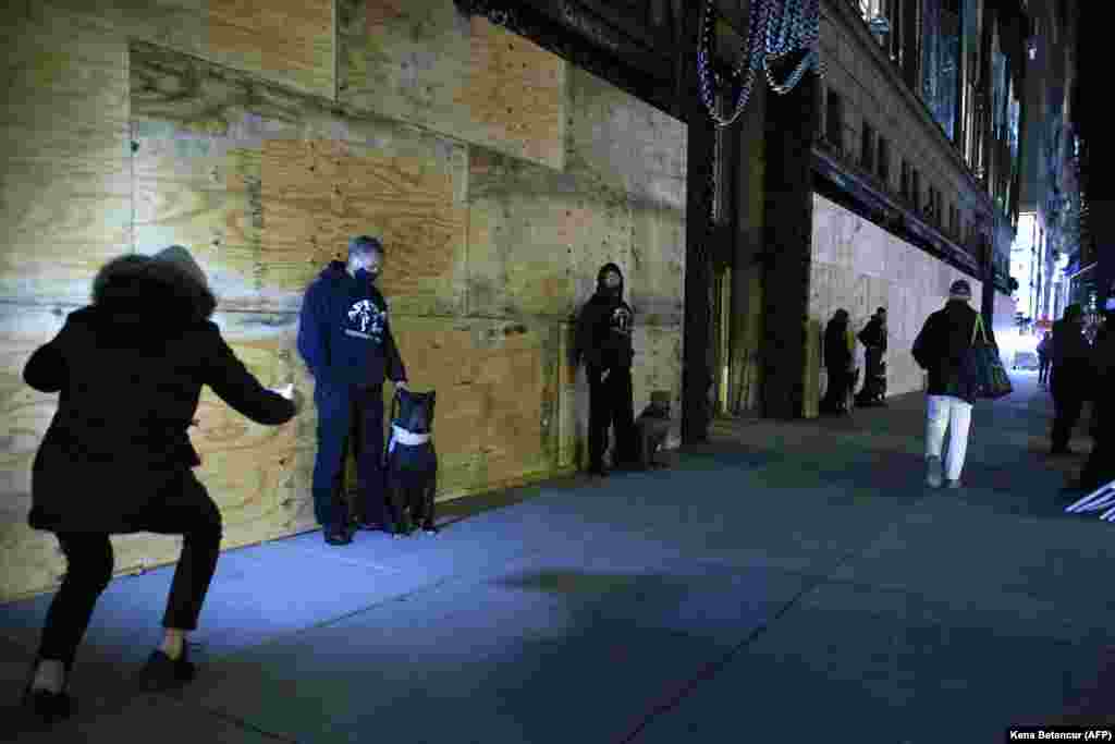 Приватите чувари стојат пред стоковна куќа Сакс на Петтата авенија ноќта пред претседателските избори во Њујорк, 2 ноември 2020 година