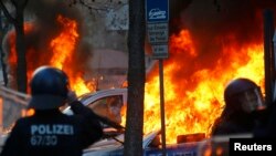 Снимката е илюстративна. Германски полицейски автомобил, подпален от антикапиталистически протестиращи, 2015 г. 