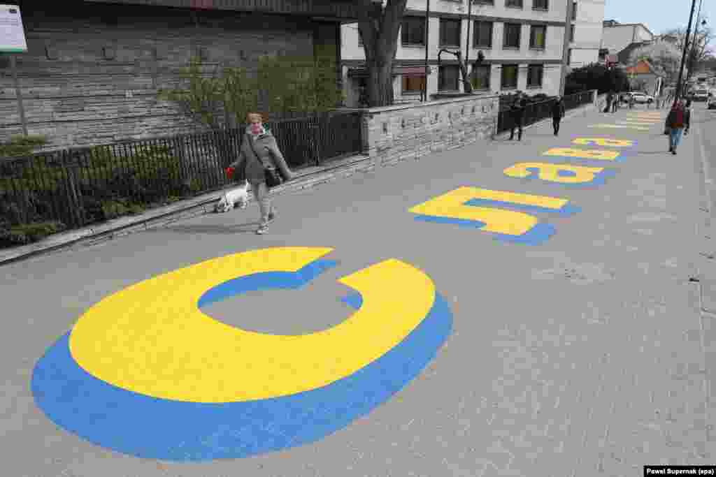 Aprilie 2022, Polonia - Un mesaj în limba ucraineană care proclamă „glorie Ucrainei” pe trotuarul din fața Ambasadei Rusiei la Varșovia.