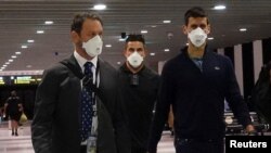 Српскиот тенисер Новак Ѓоковиќ на аеродромот во Мелбурн пред да се качи на летот, откако Федералниот суд ја потврди владината одлука да му ја укине визата за настап на Австралија опен, во Мелбурн, Австралија. 16 јануари 2022 година.