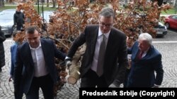 Predsjednik Srbije Aleksandar Vučić sa saradnicima unosi badnjak u zgradu Generalnog sekretarijata predsednika Republike, 6. januar 2022.