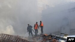 Zjarrfikësit duke e shuar zjarrin në zonën e sulmeve që e goditën një ndërtesë pranë Ambasadës iraniane në Damask, Siri, 1 prill 2024.