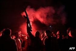 Forțele rebele trag în aer în timp ce sărbătoresc intrarea în orașul Homs, al treilea oraș din Siria.