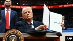 Trump arată suporterilor ordinul de ieșire a SUA din Acordul de la Paris, privind combaterea încălzirii climaterice, la mitingul din ziua depunerii jurământului.