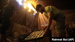 Vendors in Kabul prepare sweets on July 30 for the Eid al-Adha holiday, which is also the start of a three-day cease-fire.