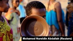 Dječak nosi tanjir u redu za hranu