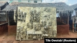 Egy újonnan készült bronztábla, amely a nyugat-afrikai Benin királyság történelmi eseményeit ábrázolja, és amelyet a British Museumnak ajánlottak fel ajándékba a nigériai Beninben 2021. július 31-én