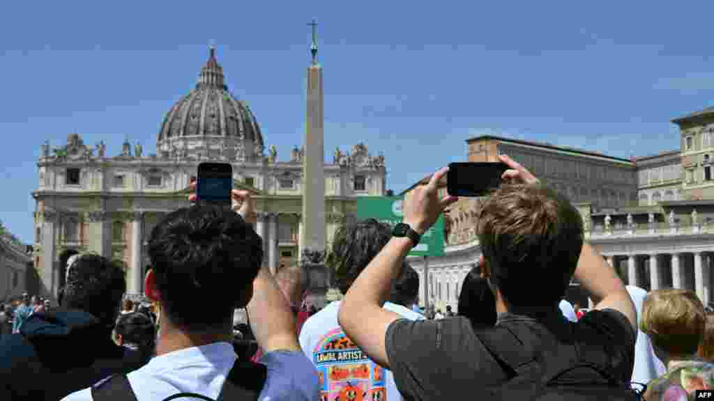Prisutni fotografišu ljude koji su se okupili povodom papine smrti.