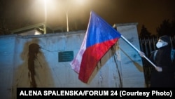 Demonstrant drži češku zastavu ispred zidova ruske ambasade u Pragu 18. aprila. Demonstranti su isprskali kečapom zidove ambasade da skrenu pažnju na smrt dvoje ljudi u eksploziji skladišta oružja 2014. za koju su Češka krive ruske agente.