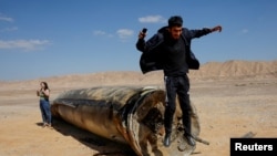 Мъж скача пред останки от балистична ракета в пустинята след нападение на Иран срещу Израел, близо до южния град Арад, Израел, 2 октомври 2024 г.