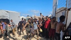 Palestinienii transportă un bărbat împușcat în timp ce aștepta să primească pachete cu alimente la un punct de distribuție administrat de Fundația Umanitară Gaza (GHF), susținută de SUA și Israel 