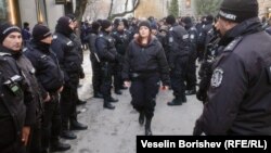 Участничка в Луковмарш преминава покрай колона от полицаи в София, 22 февруари 2025 г.